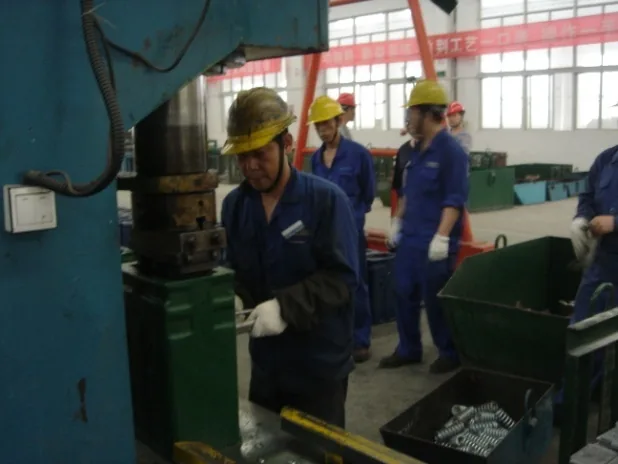 Competition scene two: employees in protective equipment work beside a forging press