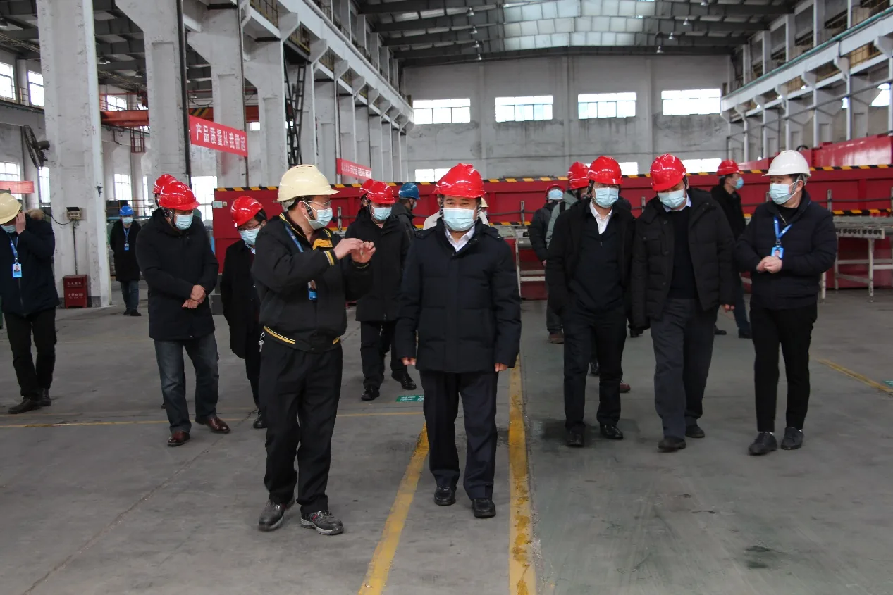 Rail industry visitors and Chunhua hosts walking through the production workshop in hard hats