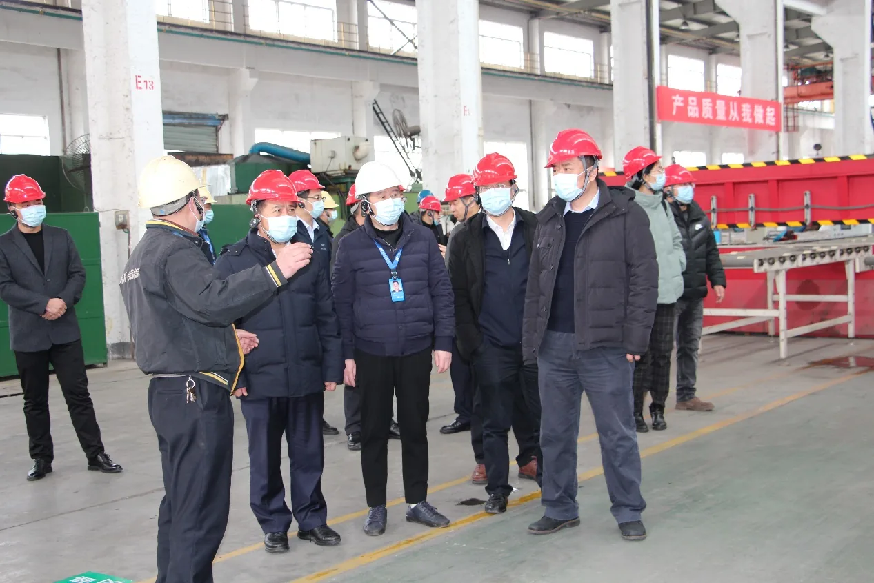 Chunhua host speaking to the delegation beside production equipment
