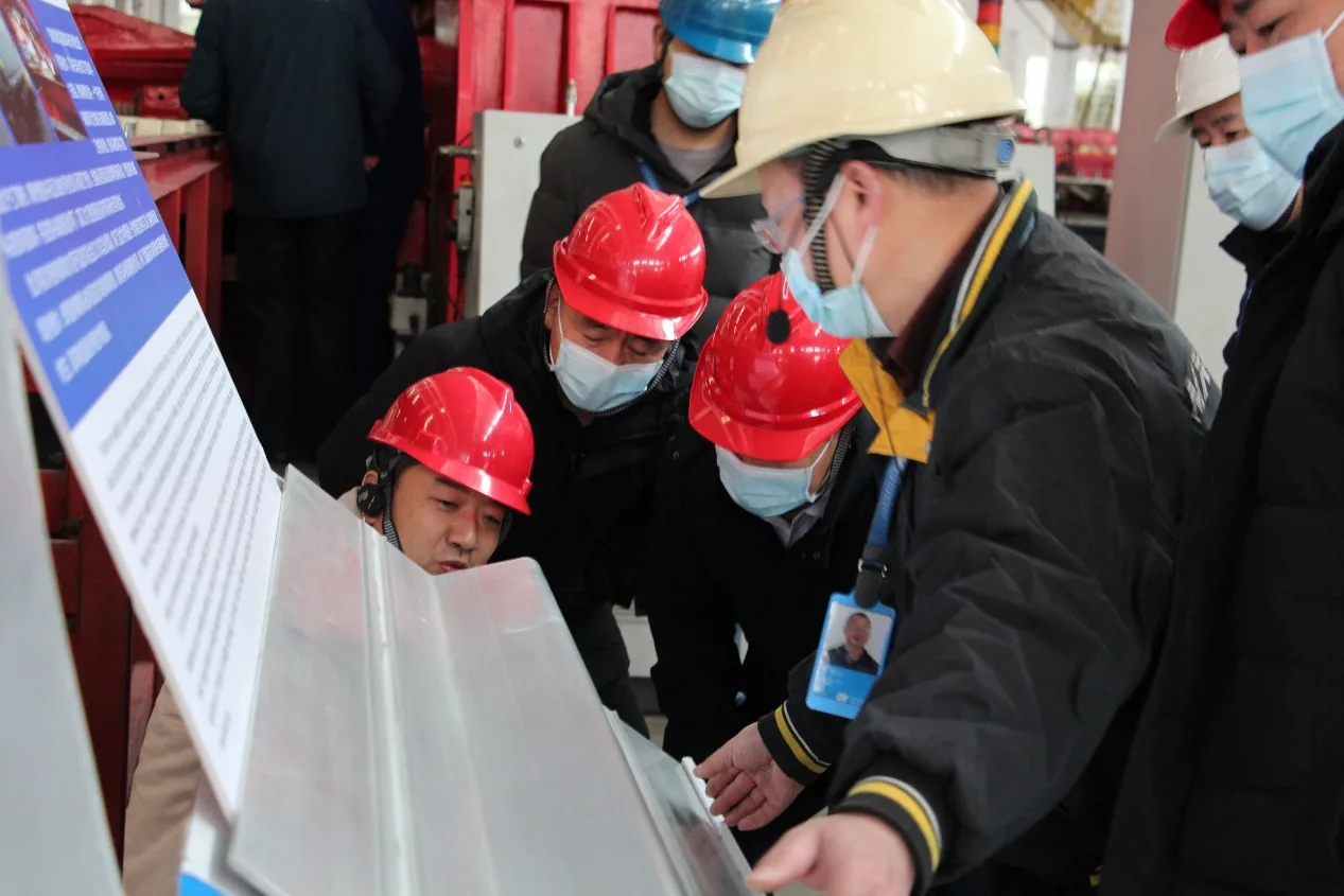 Delegation members examining a component at Chunhua’s workshop display